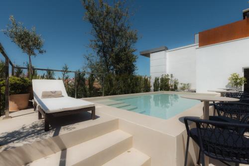 a swimming pool with a table and chairs next to a building at Cavalta Boutique Hotel GL in Seville