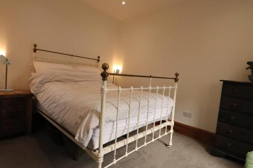 a bedroom with a white bed and a dresser at Haddon House Mews- Hopewell in Bristol