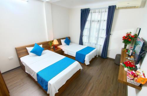 a hotel room with two beds and a window at PHÚ TRANG HOTEL in Ha Long