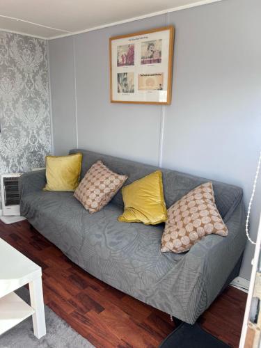 a gray couch with yellow pillows in a living room at Chalet 24 in Leysdown-on-Sea