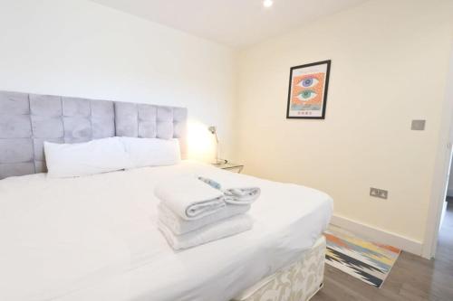 a bedroom with a large white bed with towels on it at Flat 14 Southey House in Bristol