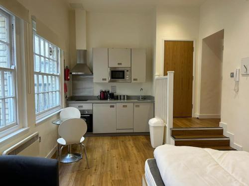 a kitchen with white cabinets and a bed in a room at Harford House studios 15- Hopewell in Bristol