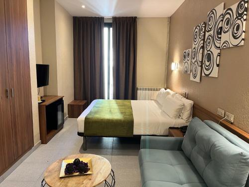 a hotel room with a bed and a couch at Pensión Iznájar Barcelona in Barcelona
