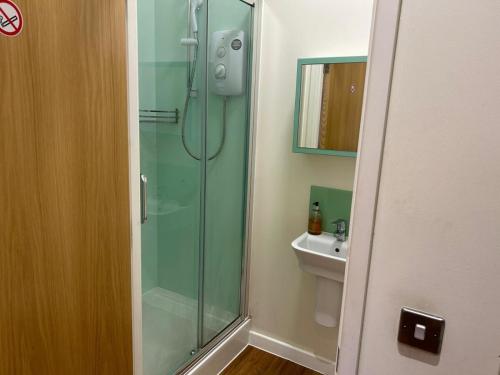 a bathroom with a glass shower and a sink at Harford House Studios 11- Hopewell in Bristol