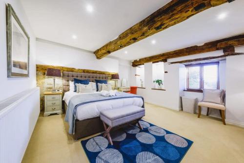 a bedroom with a large bed with a blue rug at The Granary- Hopewell in Bristol
