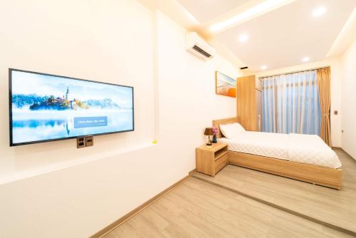 a bedroom with a flat screen tv on a wall at 2CE APARTMENT & HOTEL in Hai Phong