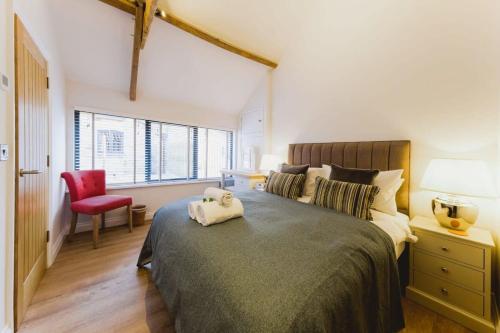 ein Schlafzimmer mit einem großen Bett und einem roten Stuhl in der Unterkunft The Hay Barn - Hopewell in Bristol
