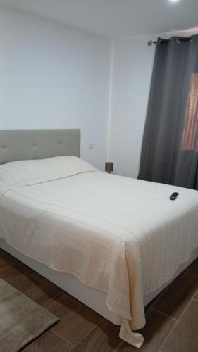 a white bed in a room with a window at Alojamento Local Casa da Eira in Murça