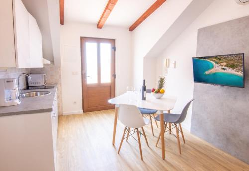 a kitchen and dining room with a white table and chairs at Apartments Portun Top Center in Baška Voda