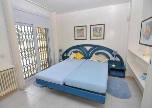 エンプリアブラバにあるRNET - Port Primer Empuriabravaの白い部屋に青いベッドが備わるベッドルーム1室
