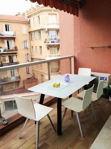 einen Tisch und Stühle auf einem Balkon mit Blick auf ein Gebäude in der Unterkunft Large Studio 907T near Monte Carlo Casino Monaco in Monte Carlo