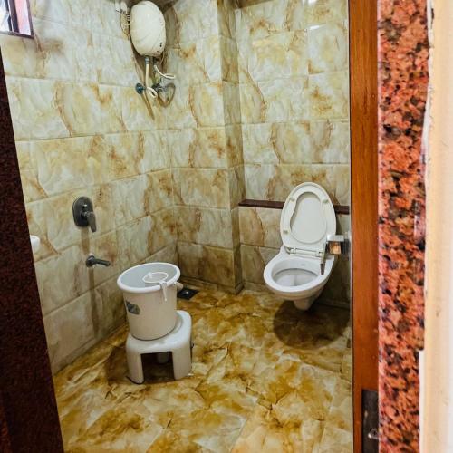 a bathroom with a toilet and a sink at Hotel Sigma in Ahmedabad