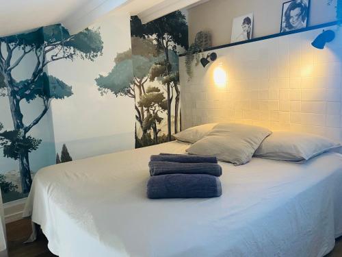 - un lit avec 2 serviettes assises au-dessus dans l'établissement VILLA NATURISTE HELIOVILLAGE - CAP D'AGDE - 2 PERS, au Cap d'Agde