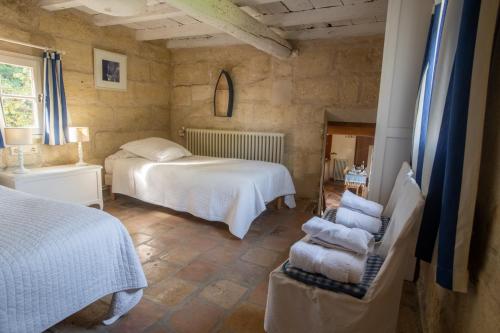 a bedroom with two beds and a chair at HOTEL et APPARTEMENTS DOMAINE DES CLOS - Teritoria in Beaucaire