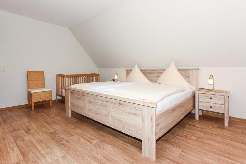 ein Schlafzimmer mit einem Bett, zwei Tischen und einem Stuhl in der Unterkunft Landhaus am Grafthof in Neuharlingersiel