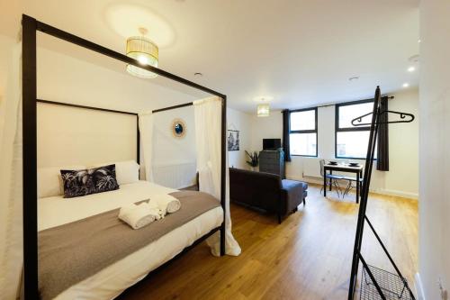 ein Schlafzimmer mit einem Himmelbett und einem Schreibtisch in der Unterkunft Hotwells apartments flat 1 - Hopewell in Bristol