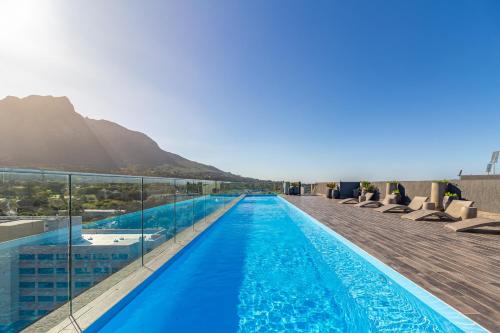 ein Schwimmbad mit einem Berg im Hintergrund in der Unterkunft Newlands Peak Apartments in Kapstadt