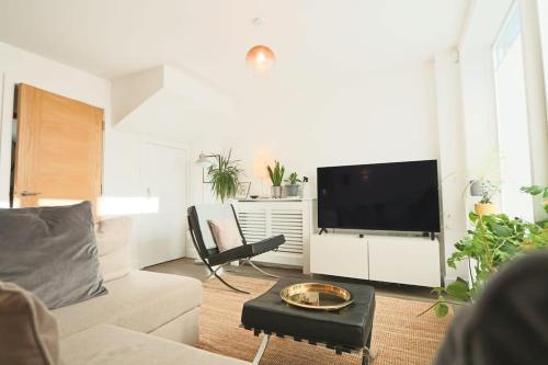 a living room with a couch and a flat screen tv at Cooperage 3 bedroom house in Bristol