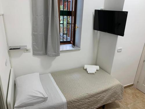 1 dormitorio con 1 cama y TV en la pared en MIRIS home fast and comfortable with self check in 8 minutes walk near Naples airport en Nápoles
