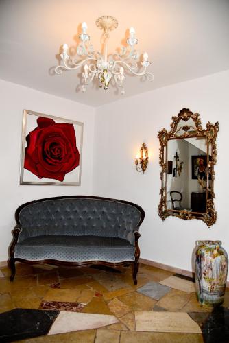 a room with a couch and a mirror and a chandelier at Pension Langerspacher in Grabenstätt