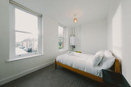 Habitación blanca con cama y ventana en West Street 194- Hopewell, en Bristol