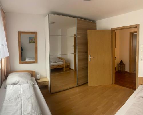 エルヴァンゲンにあるFerienwohnung "Zwei Birken"のベッドルーム(ガラス張りのクローゼット、ベッド1台付)