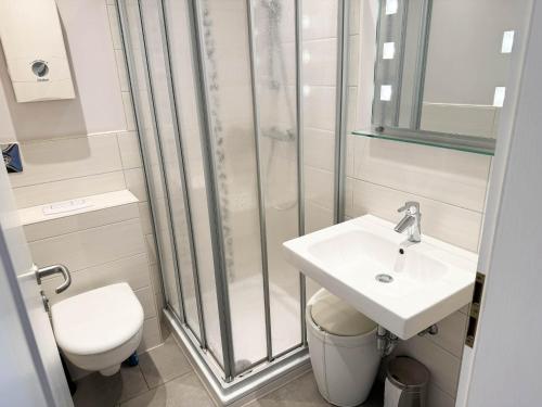 ein Bad mit einer Dusche, einem Waschbecken und einem WC in der Unterkunft Haus Nordseeblick Wohnung 9 in Büsum