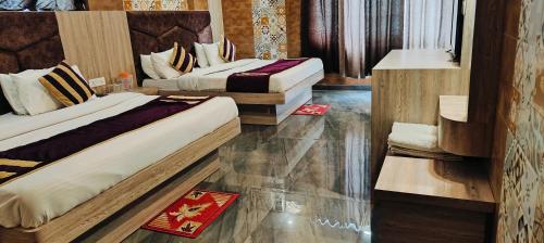 two beds in a hotel room at Hotel Sunshine in Katra