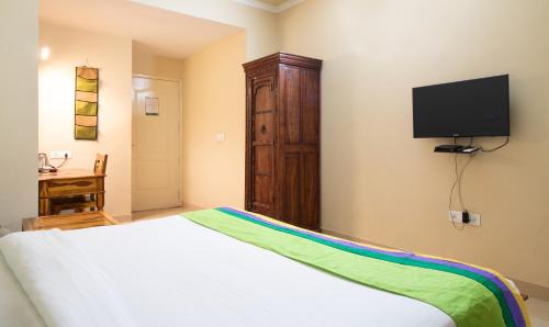 a bedroom with a bed and a flat screen tv at Treebo The Anchorage Malviya Nagar in Jaipur