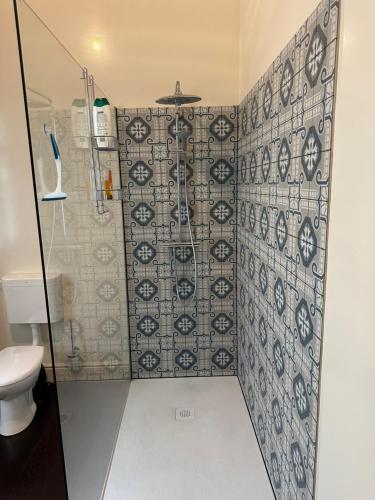 La salle de bains est pourvue d'une douche avec du carrelage bleu et blanc. dans l'établissement Chambre hôte, à Bruxelles