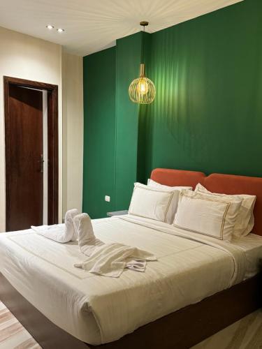 a bedroom with a large bed with a green wall at Almas Pyramids Hotel in Cairo