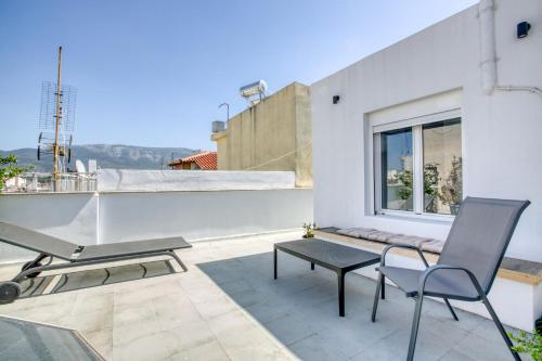 a balcony with a table and chairs and a window at Anais - Solo traveller rooftop in Athens