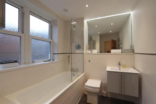 a bathroom with a toilet and a sink and a shower at Quiet riverside apartment with views and parking- in Bristol