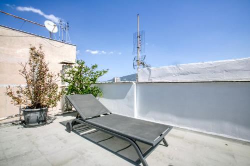 a chair sitting on a patio on a roof at Anais - Solo traveller rooftop in Athens