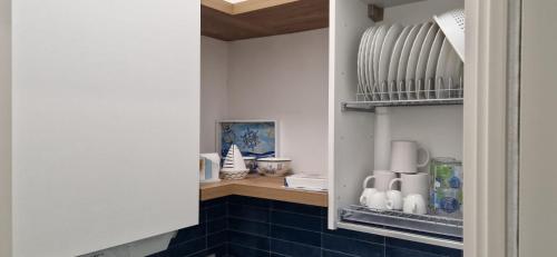 uma pequena cozinha com azulejos azuis e electrodomésticos brancos em Casa Vacanze Marinella Beach em San Vito lo Capo