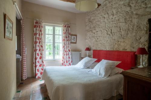 a bedroom with a bed with red and white curtains at HOTEL et APPARTEMENTS DOMAINE DES CLOS - Teritoria in Beaucaire