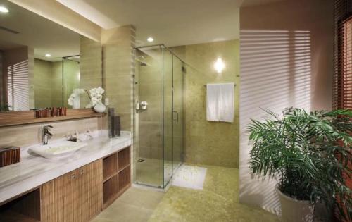 a bathroom with a sink and a glass shower at The Cliff Residence in Mui Ne