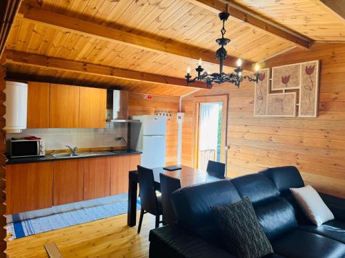 a living room with a black couch and a kitchen at VilleLay Alojamento VNG in Vila Nova de Gaia