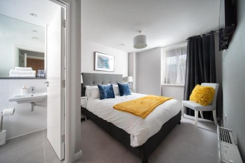 1 dormitorio con 1 cama y baño con lavamanos en Deluxe Apartment near Cabot Circus w Parking sleeps 5 en Bristol
