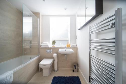 y baño con aseo, lavabo y ducha. en Deluxe Apartment near Cabot Circus w Parking sleeps 5 en Bristol