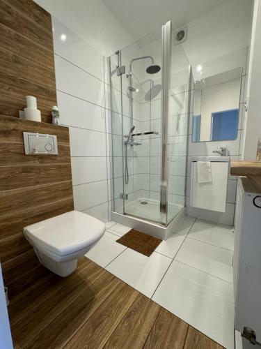 Un baño blanco con ducha y WC. en White House, en Varsovia
