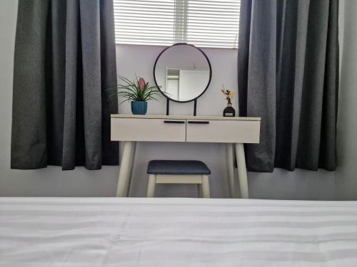 a dressing table with a mirror and a chair at Modern And Spacious 3 Bedroom Family House with Workspace in Colchester
