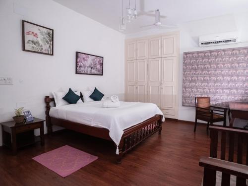 Schlafzimmer mit einem Bett, einem Tisch und einem Schreibtisch in der Unterkunft The White House Opp Park Hyatt in Chennai