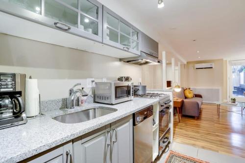 a kitchen with a sink and a microwave at Beautiful 2 Bedroom across from The House of Representatives in Washington, D.C.
