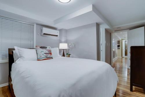 1 dormitorio con 1 cama blanca grande y pasillo en Beautiful 2 Bedroom across from The House of Representatives, en Washington
