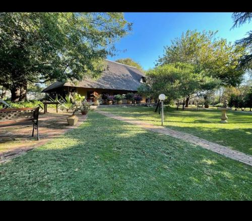 a large building with a grass yard with a building at Midrand Wild Goose Guest House Backup Power in Midrand