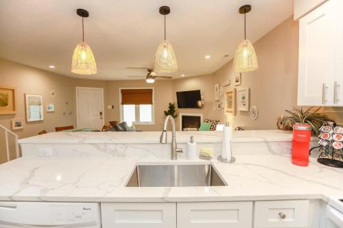 a kitchen with a sink and two pendant lights at Sojourn The Ocean Breeze in Virginia Beach in Virginia Beach