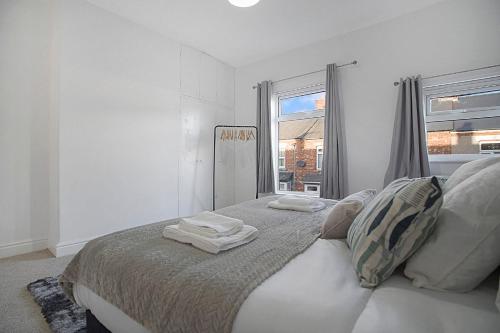 a white bedroom with a bed with towels on it at Peaceful Dwelling at Falmer Road, Sleeps 4 in Darlington