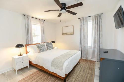 um quarto com uma cama e uma ventoinha de tecto em Sojourn Coastal Cottage 3 BR em Norfolk