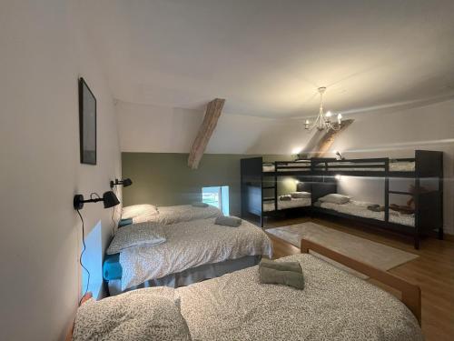 1 dormitorio con 2 camas y lámpara de araña en Al Bioule - Maison climatisée avec piscine, en Penne-dʼAgenais